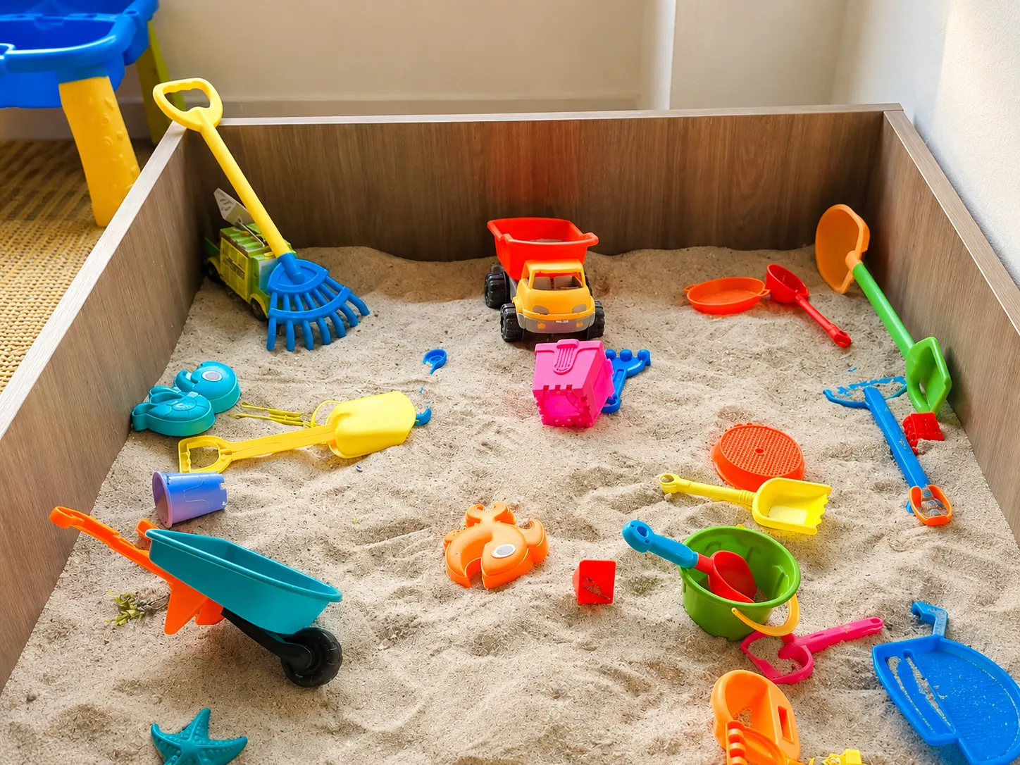 Arenero infantil con materiales de exploración sensorial