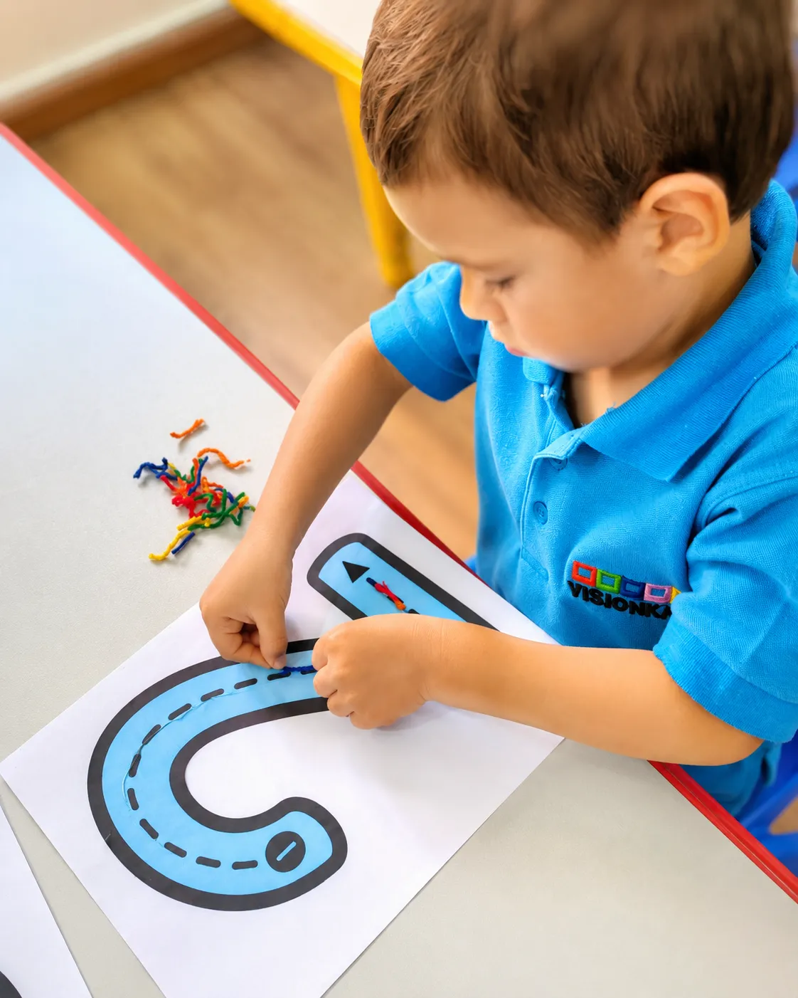 Niño desarrollando motricidad fina mediante una actividad educativa en VisionKids