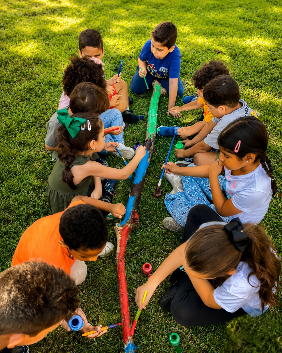 Grupo de niños colaborando en un proyecto artístico al aire libre